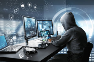 Penetrační tester sedí u počítače a hackuje síť