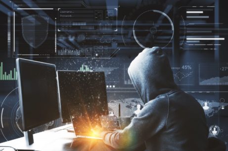 Hacker sedící za počítačem se snaží nabourat do podnikové sítě
